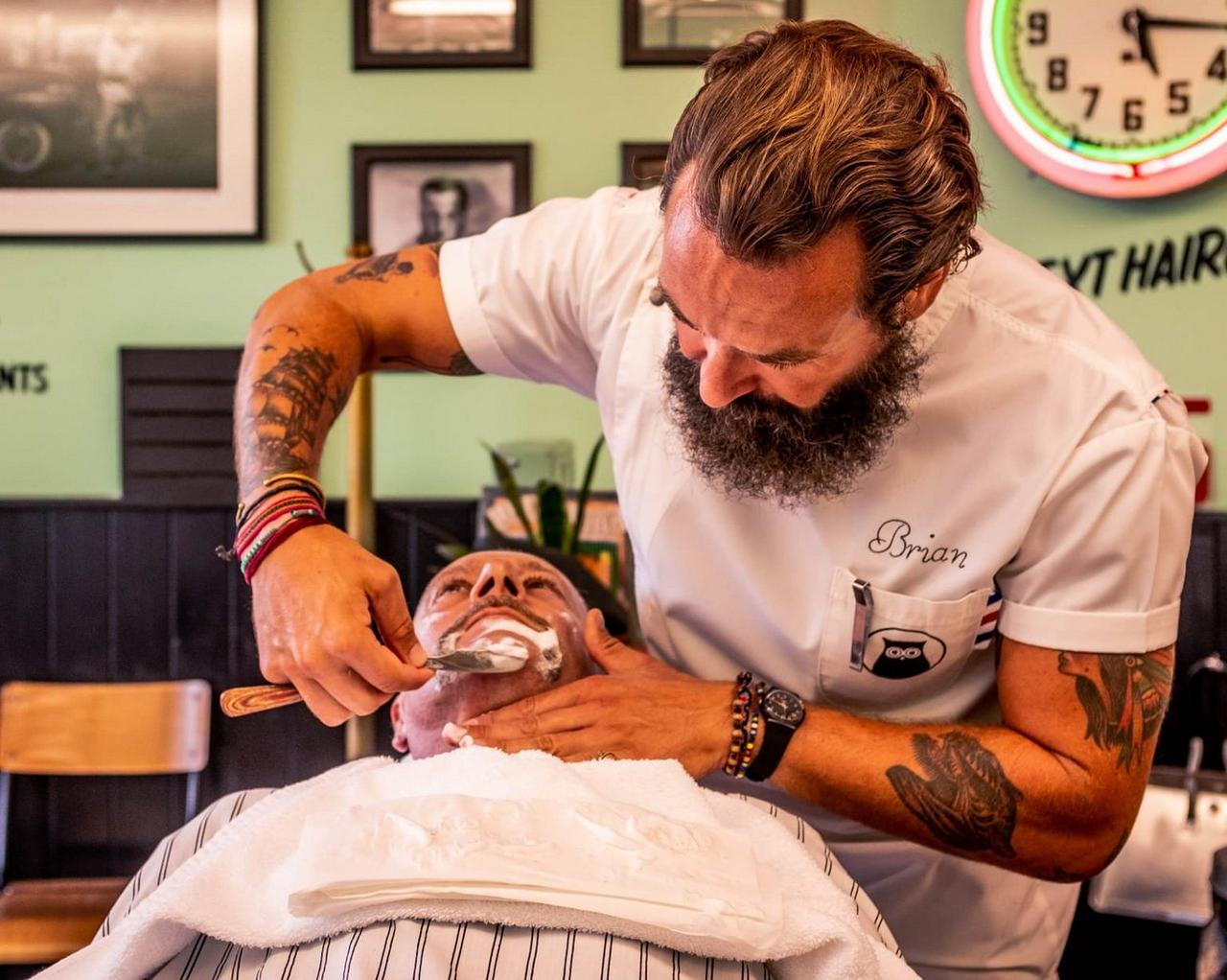 Brian Hurson, barbier, taillant la barbe d’un client