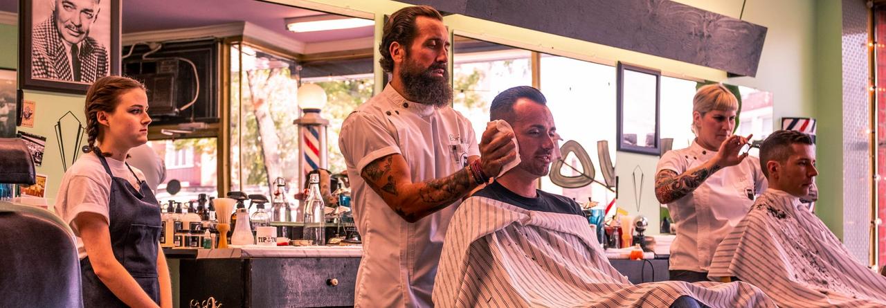Brian Hurson, a barber, with a client in salon