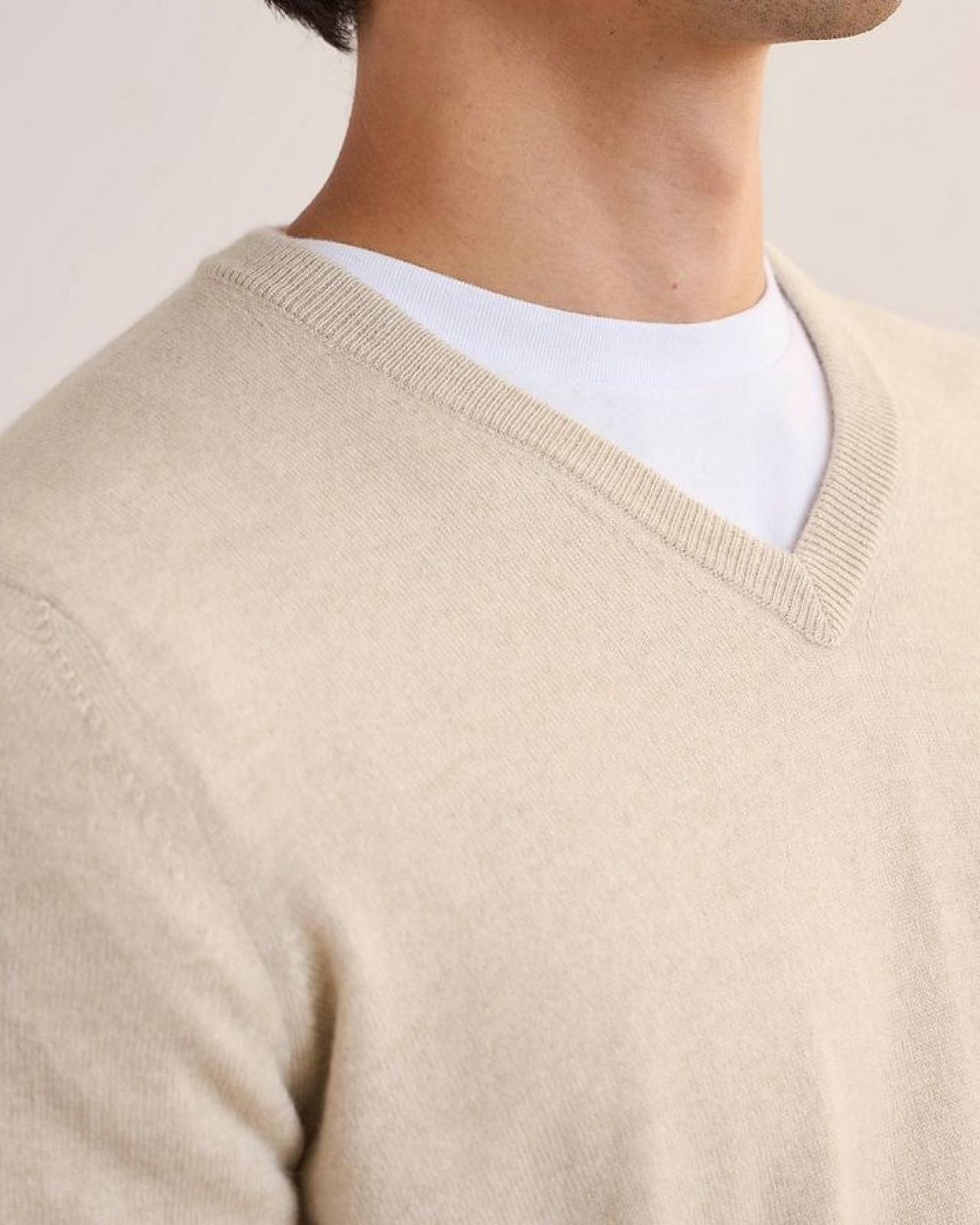 A man wearing a off white cashmere sweater