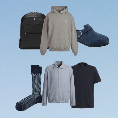 Travel essentials layout featuring a backpack, hoodie, socks, button-down shirt, and T-shirt on a blue background