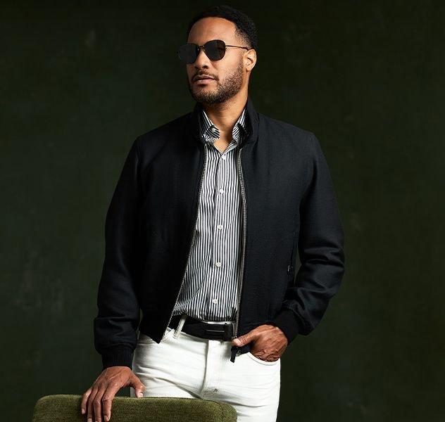 Male model wearing a TOM FORD jacket, casual shirt, and white pants