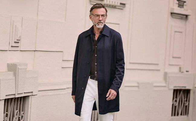 A man wearing a Zegna coat layered over a shirt and pants