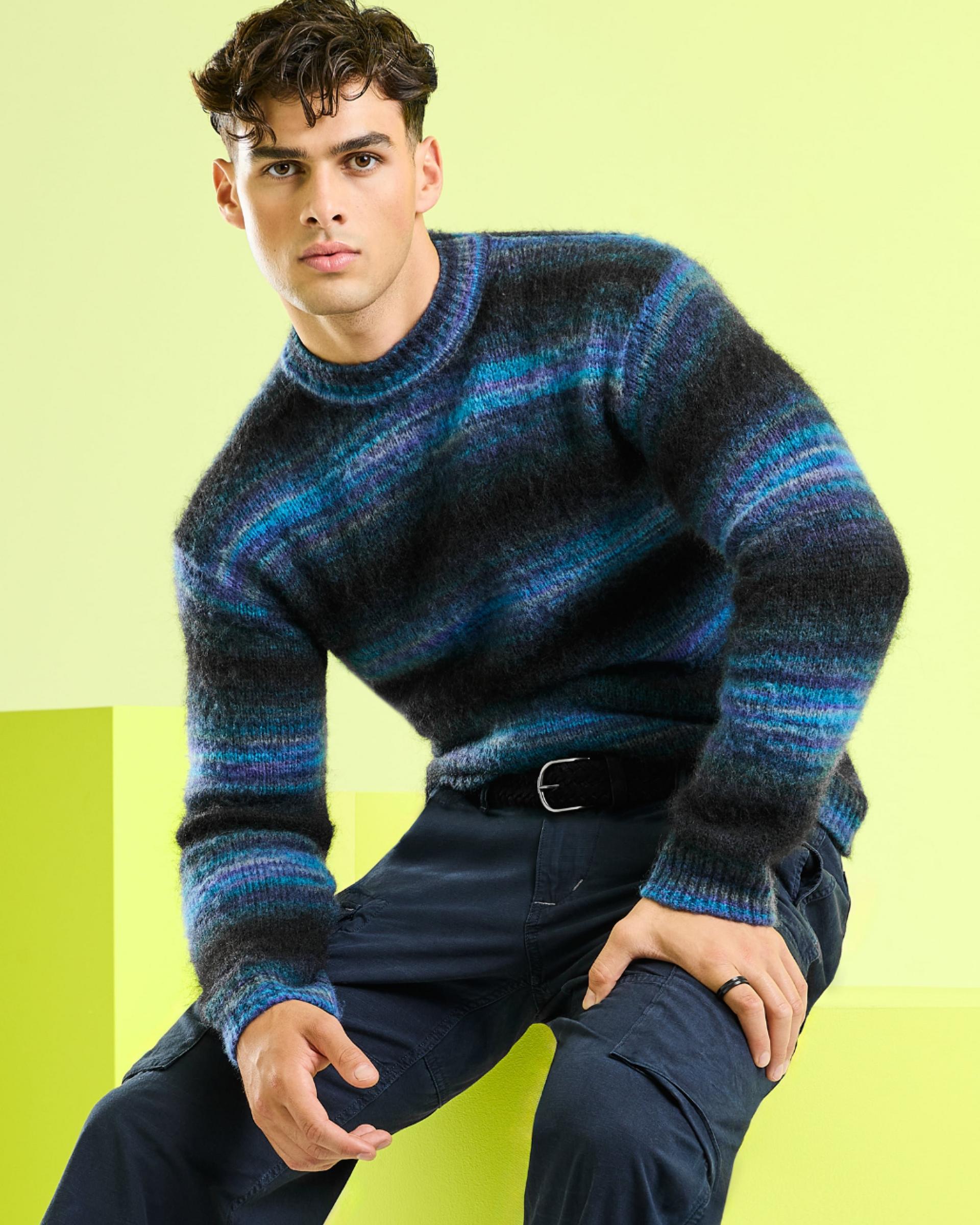 A male model wearing a blue knit sweater