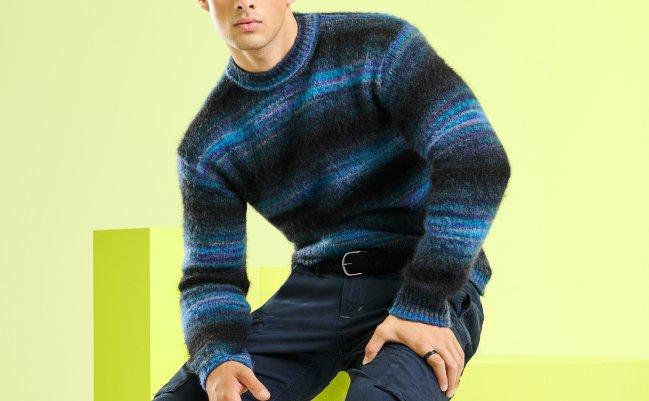 A male model wearing a blue knit sweater