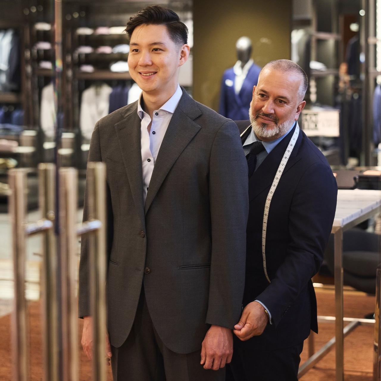 Conseiller en style aidant un client à choisir une complet