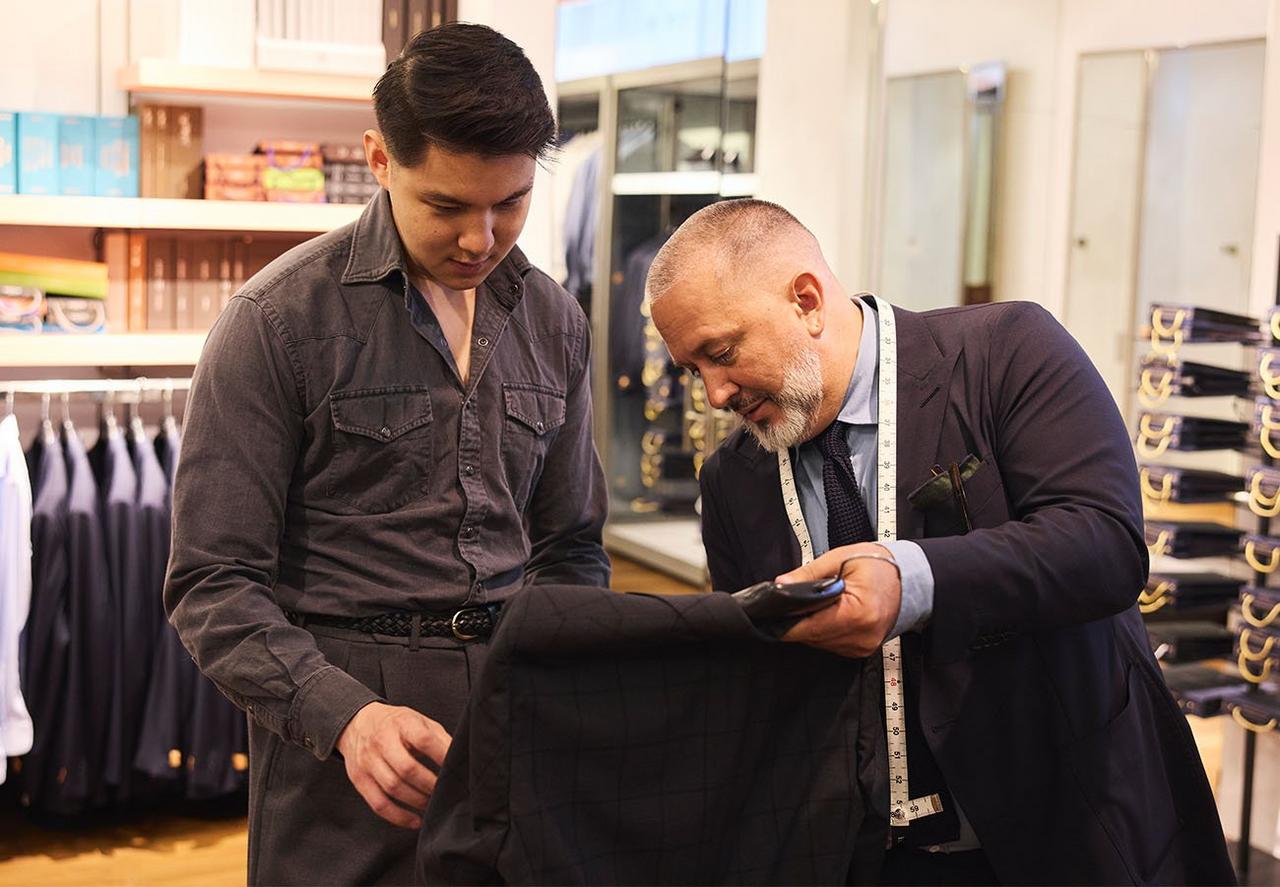 Deux hommes examinant un veston sport tout en explorant des options sur mesure