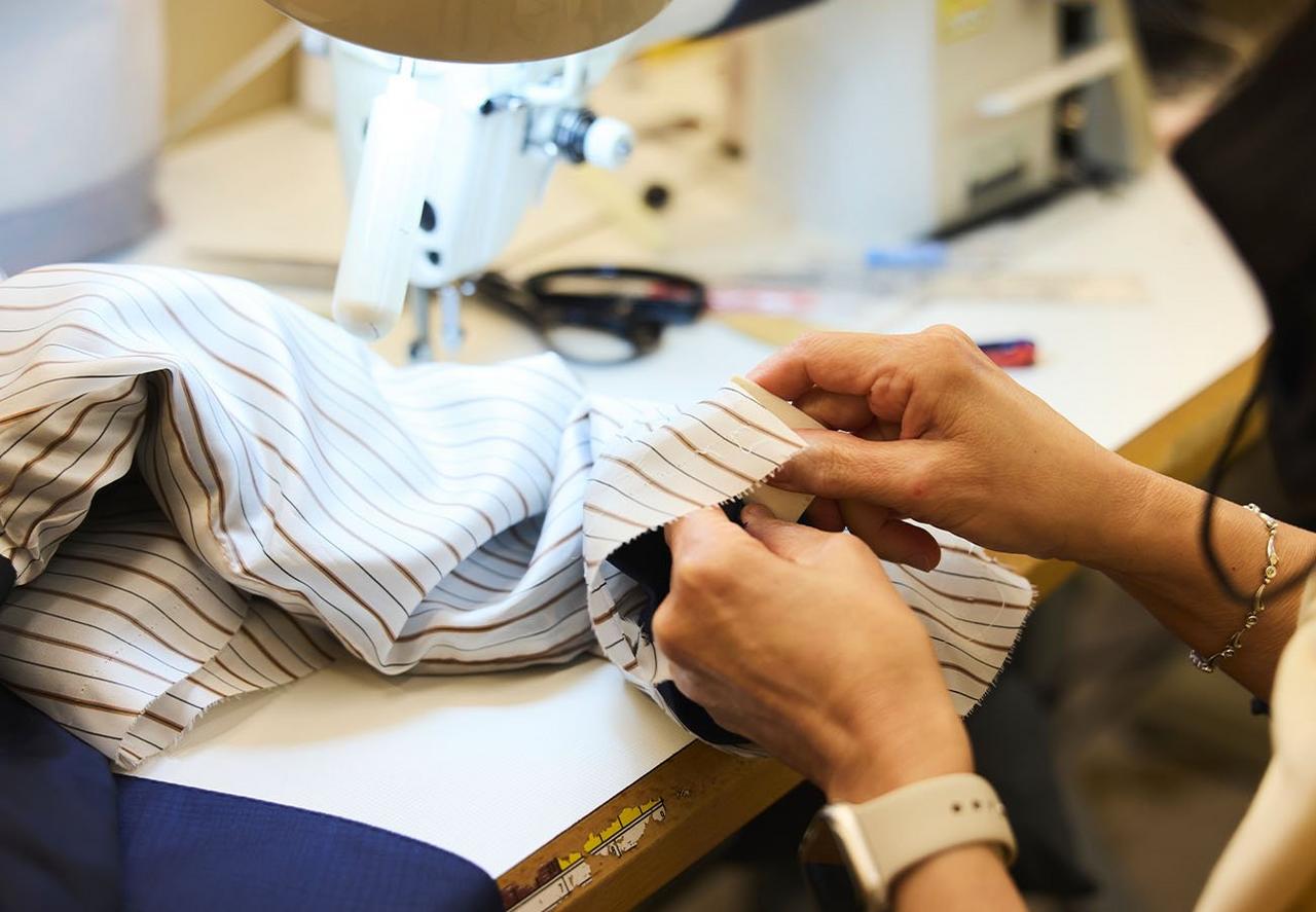 Tailleur cousant une chemise habillée