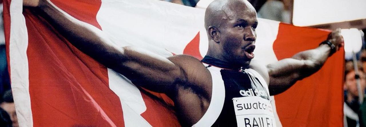 Donovan Bailey, le plus grand athlète canadien, tenant le drapeau du Canada