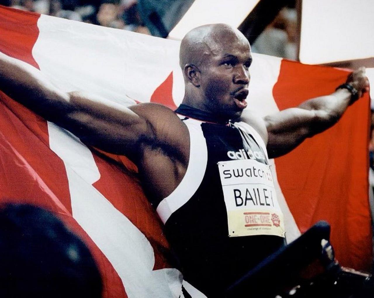 Donovan Bailey, le plus grand athlète canadien, tenant le drapeau du Canada