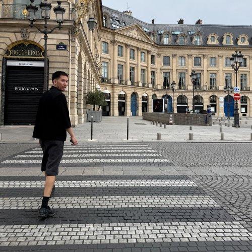 Buyer crossing patterned pavement in front of the Palais-Royal in Paris