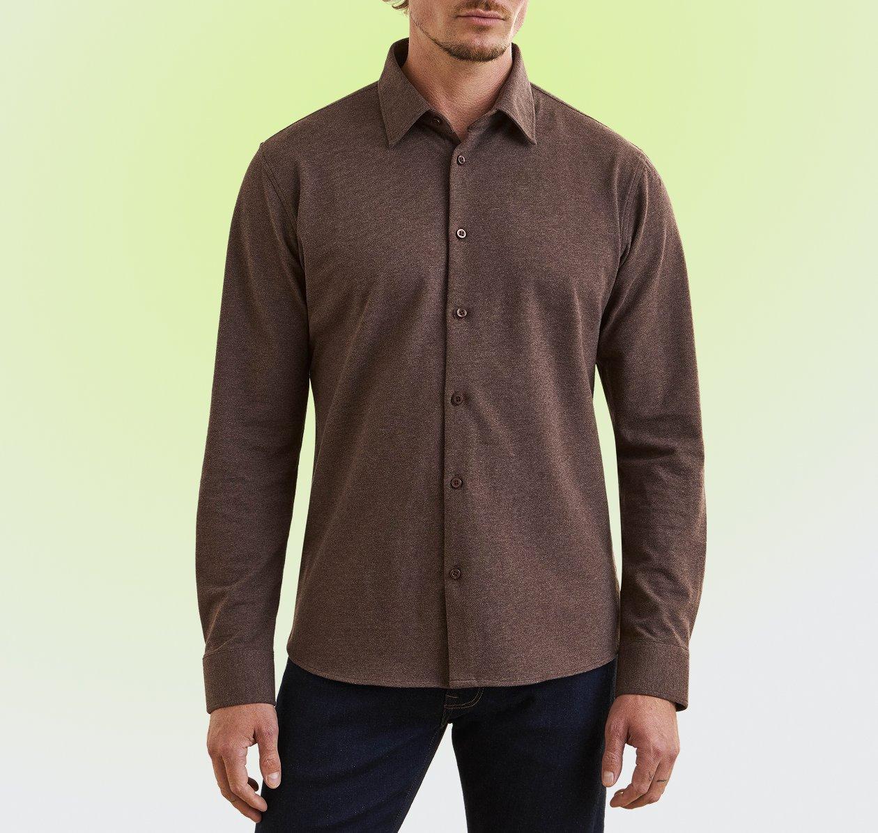 Man wearing a brown long-sleeve button-up shirt and dark navy trousers.