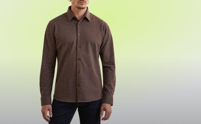Man wearing a brown long-sleeve button-up shirt and dark navy trousers.