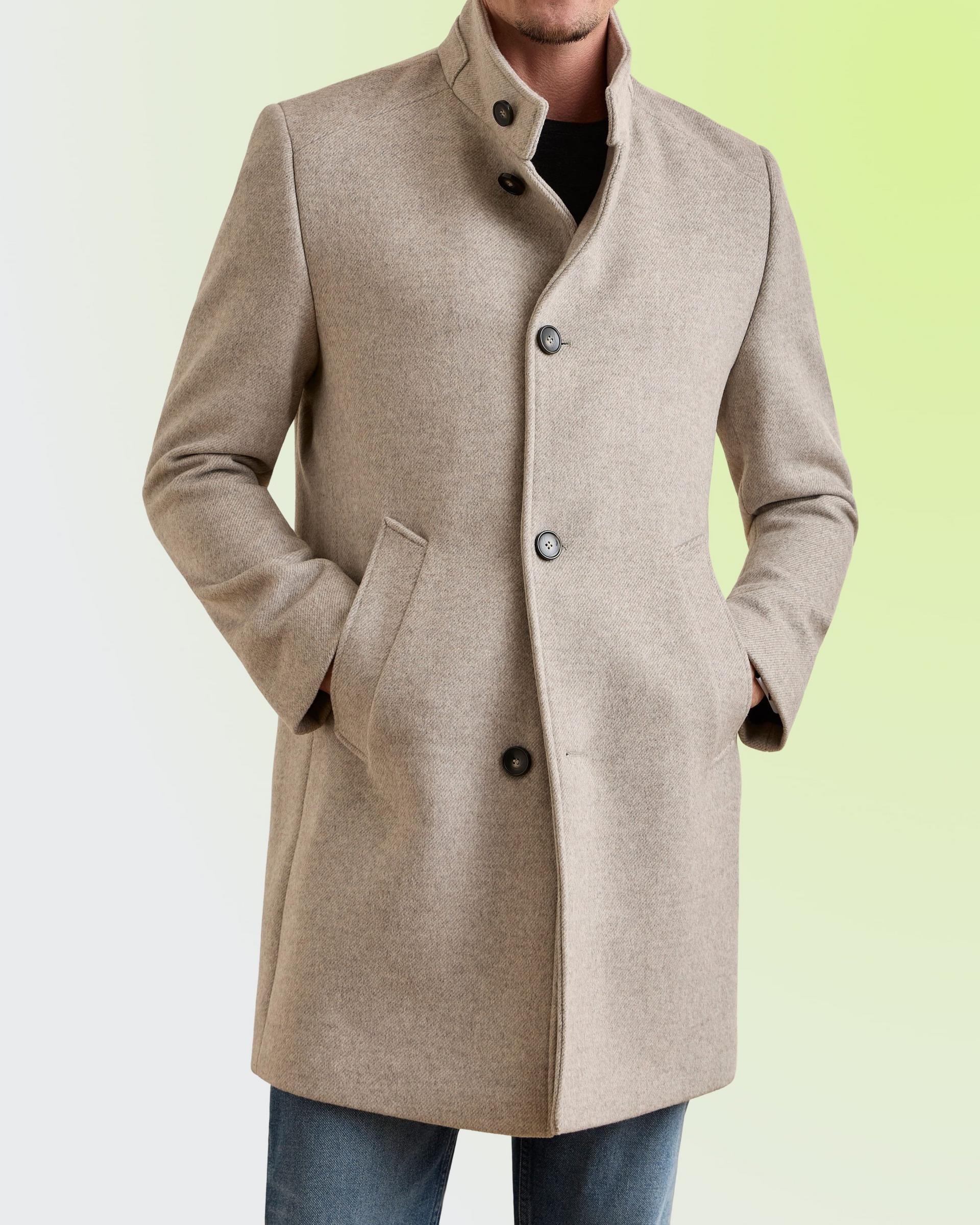 Man wearing a beige wool stand-collar coat by Bugatti over a black tee and jeans, FW26 collection