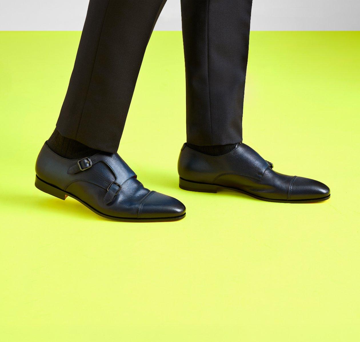 Man wearing black trousers and black leather double monk strap shoes