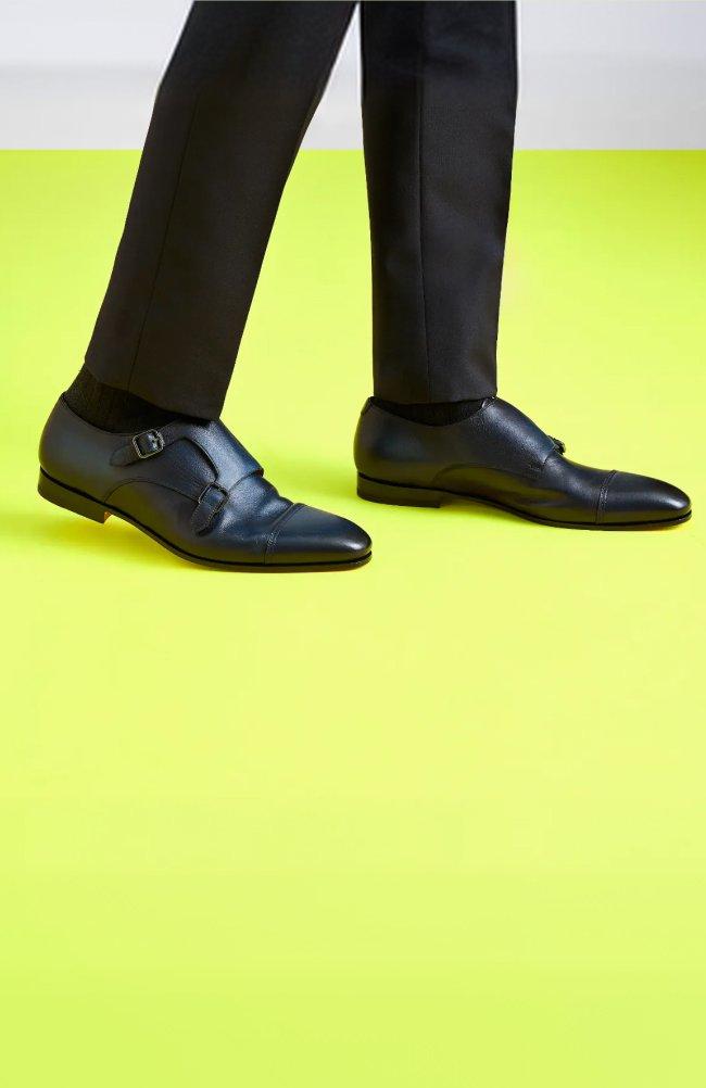 Homme portant un pantalon noir et des chaussures en cuir noir à double boucle