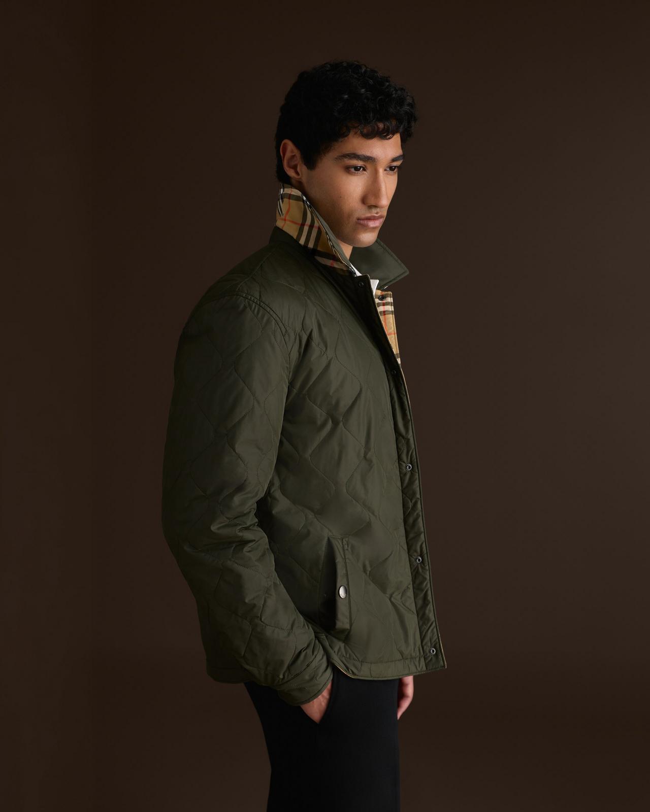 Homme portant une veste matelassée vert olive avec col à motif check de Burberry, collection A/H26
