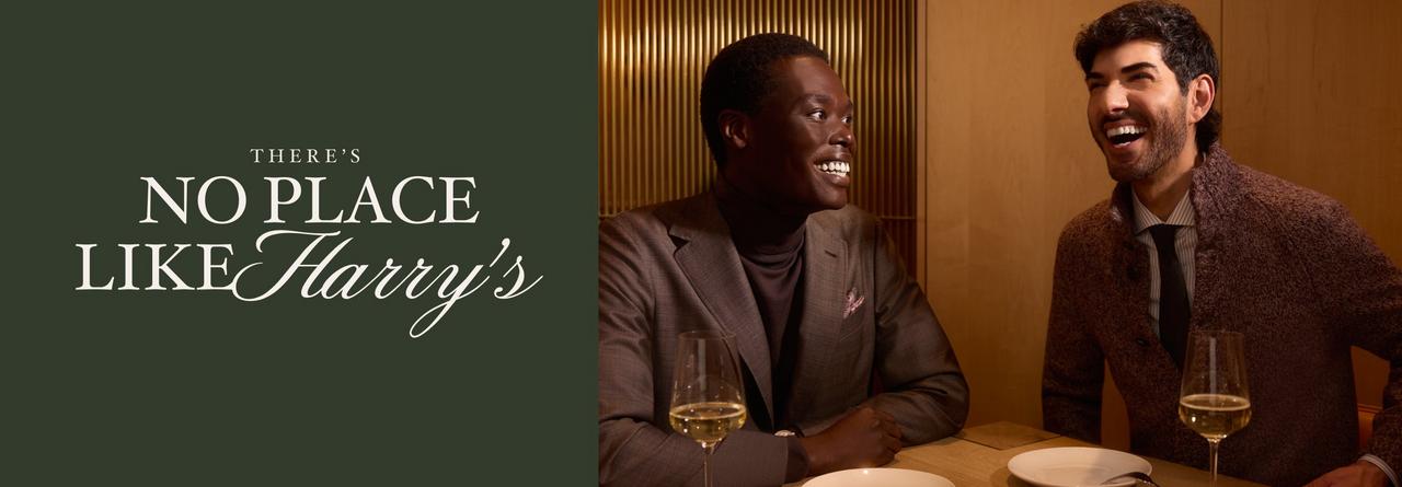 Two men in tailored suits enjoying a conversation over wine at a restaurant, with the text “There’s No Place Like Harry’s