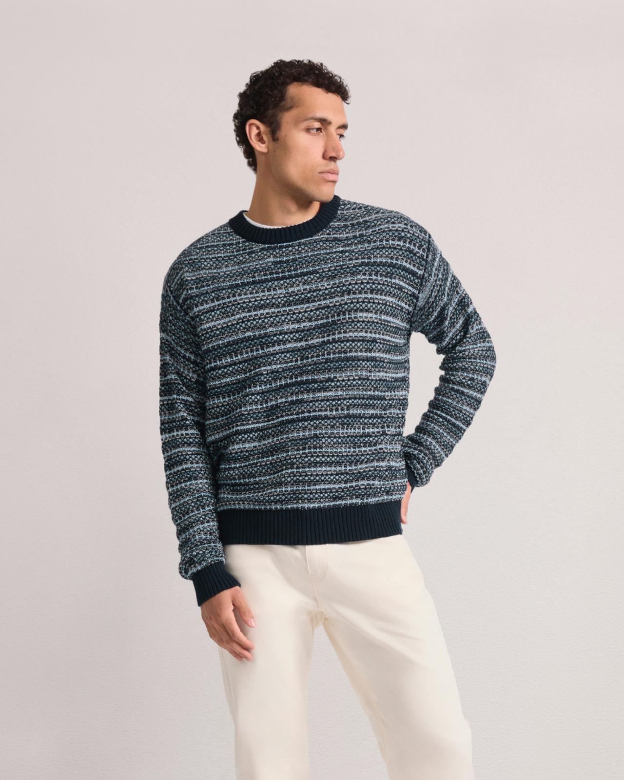 Homme portant un pull à col rond rayé associé à un pantalon de couleur claire