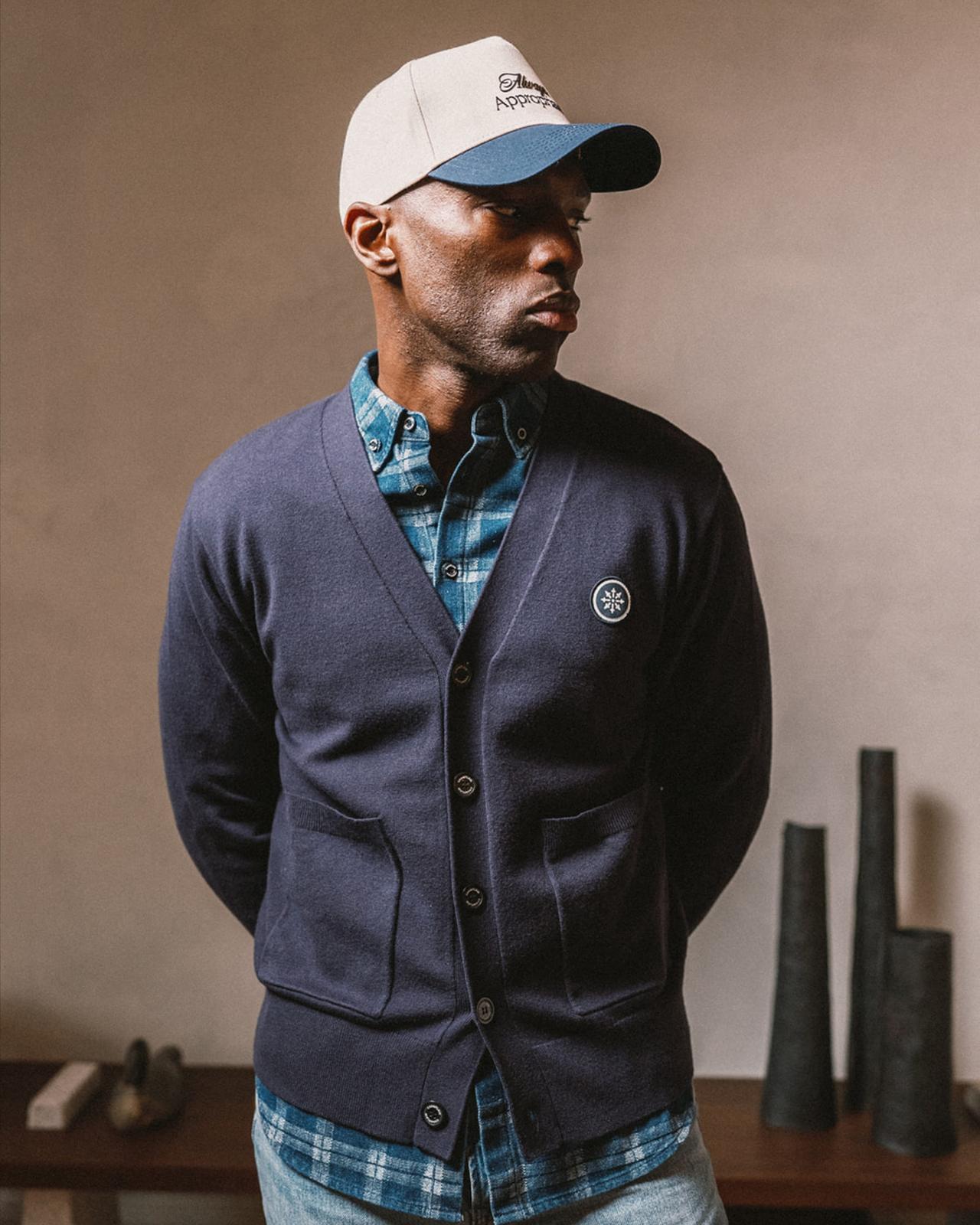Mannequin portant du bleu marine, associé à une chemise à carreaux bleus et un jean