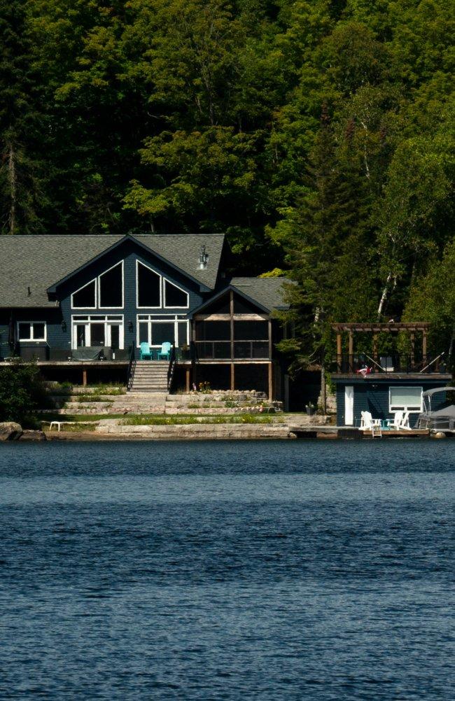 image d'un chalet au bord d'un lac avec un quai