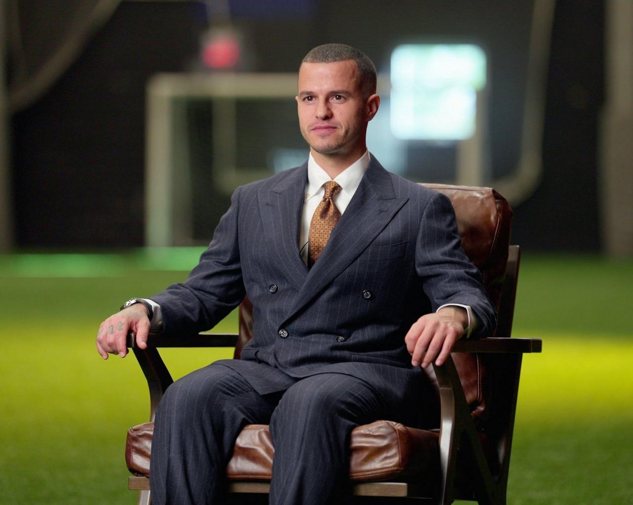 Sebastian Giovinco in a suit seated in an armchair