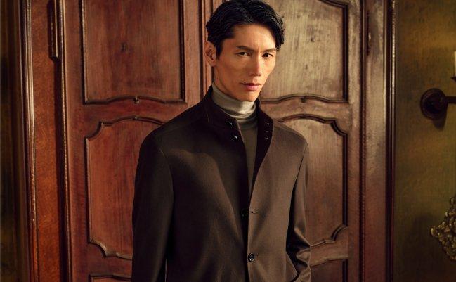 FW26 – Zegna Drop 3 — Model wearing a sophisticated brown tailored jacket, taupe turtleneck, and beige trousers.