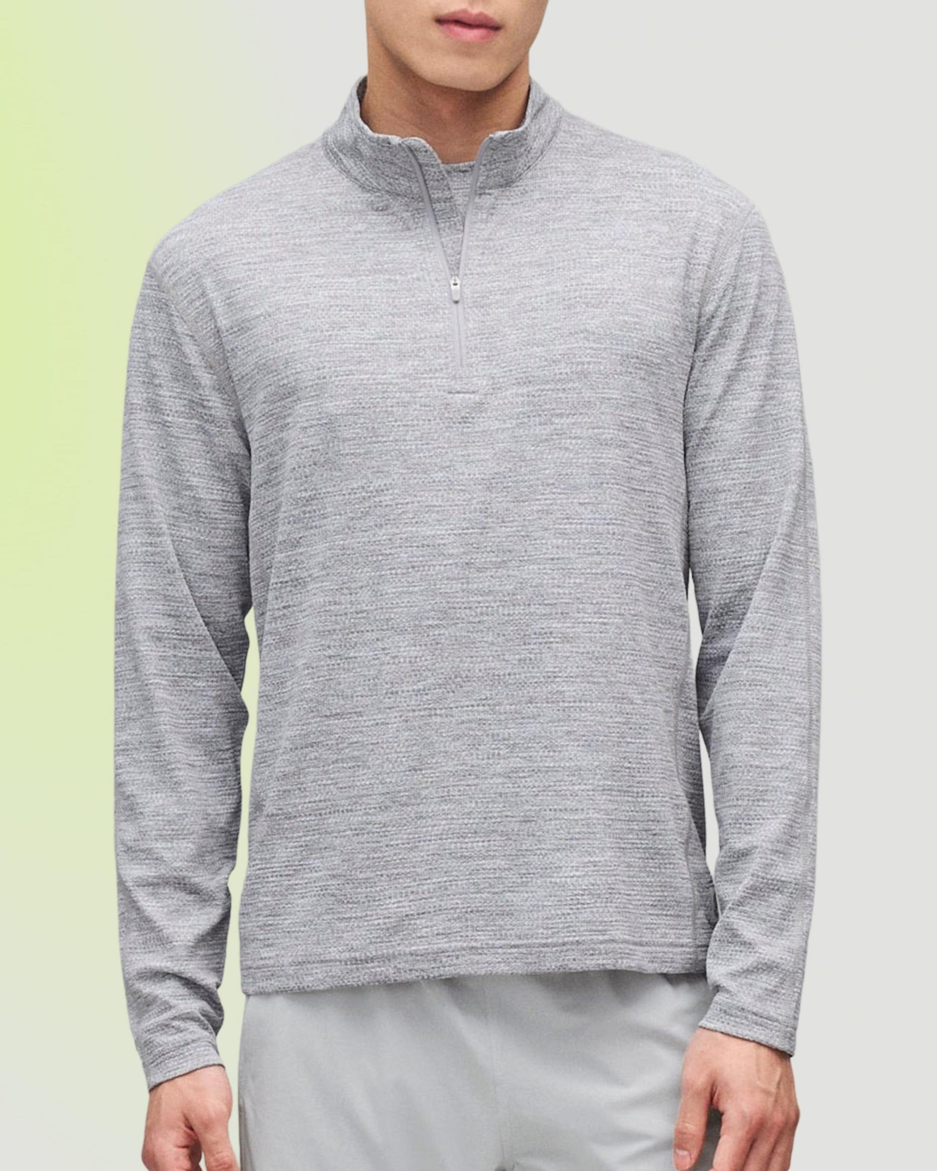 Man wearing a grey heathered quarter-zip pullover and grey athletic shorts by Reigning Champ, FW26 collection