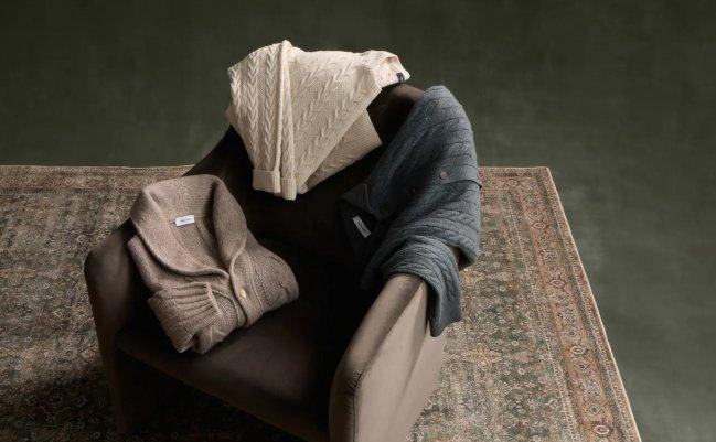 Trois pièces en tricot torsadé de Gran Sasso, un cardigan taupe à col châle, un chandail torsadé crème et un cardigan torsadé charbon, disposés sur un fauteuil, Knitwear Option 2, collection A/H26