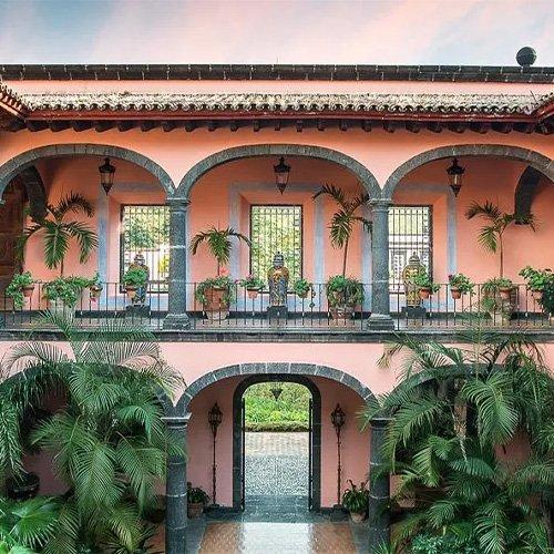 A courtyard with a fountain and a balcony with plants
