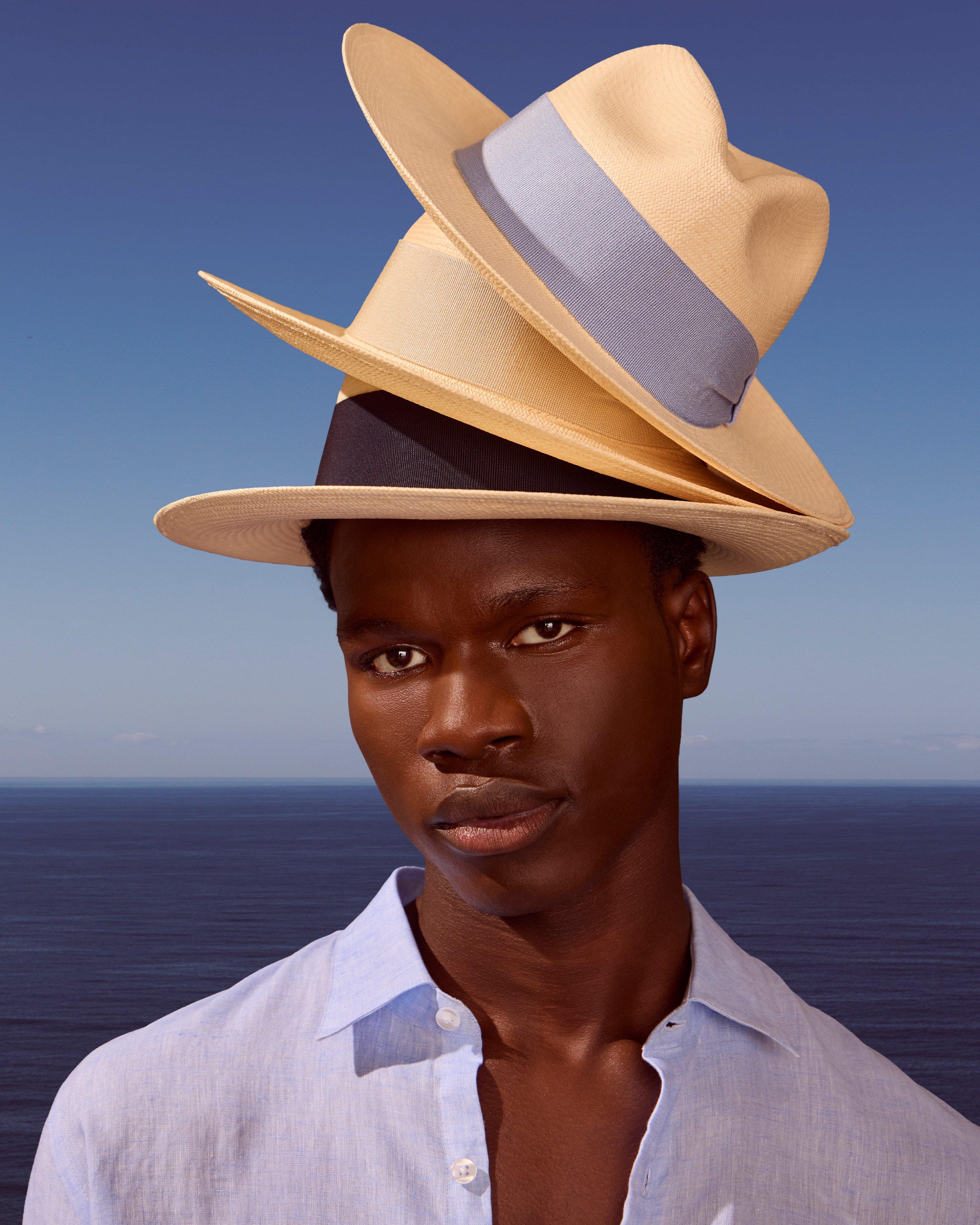 A man with three hats on his head, one on top of the other