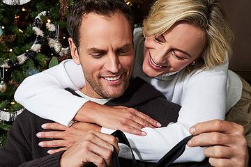 Holiday joy captured as man and woman embrace over a Harry Rosen gift