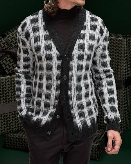 Model displaying Marni Checkered Mohair Cardigan against dark green gift boxes background