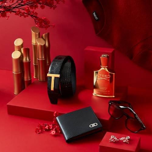 A red background with a wallet, sunglasses, and other items