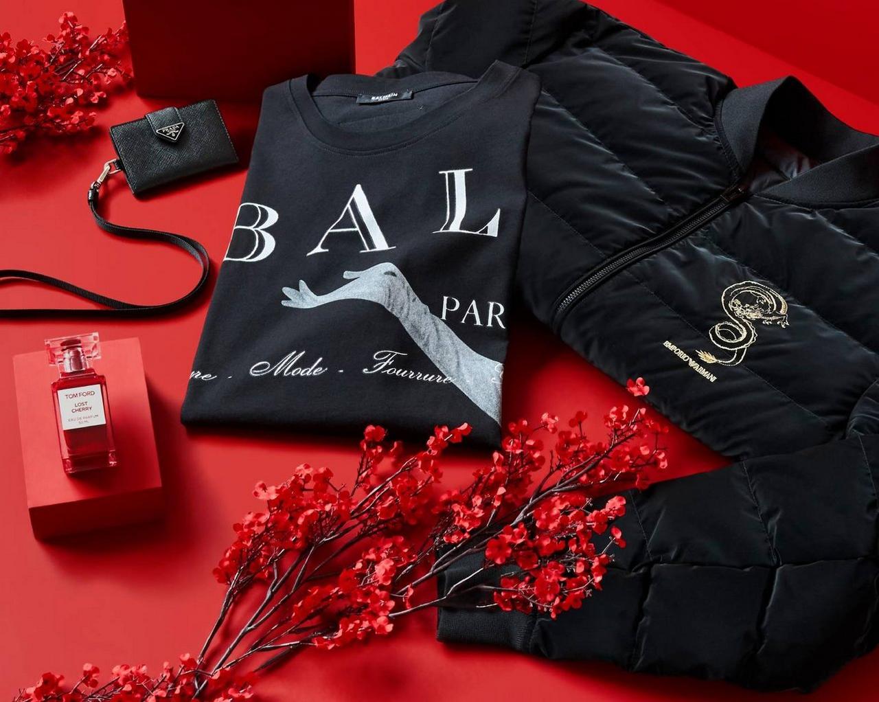 A red and black jacket, a red purse, and a red bottle of perfume