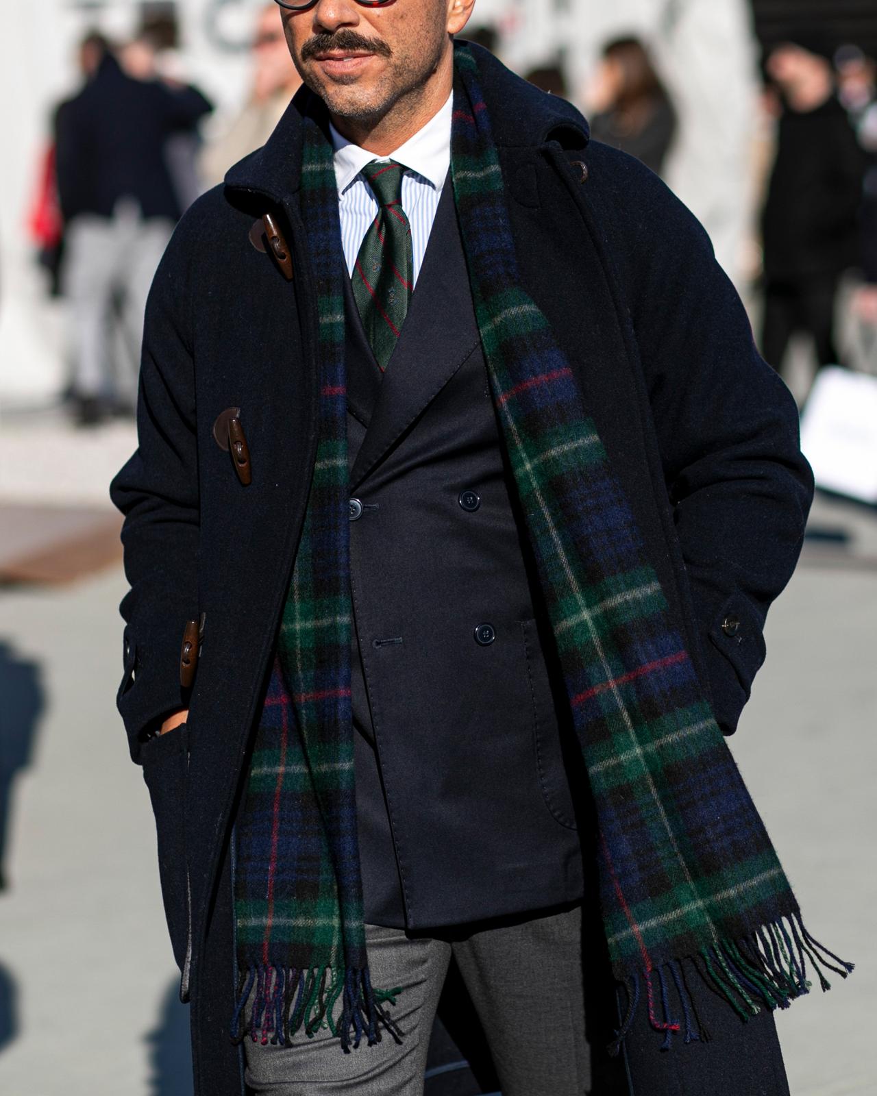 Man wearing layered outfit look with patterned scarf