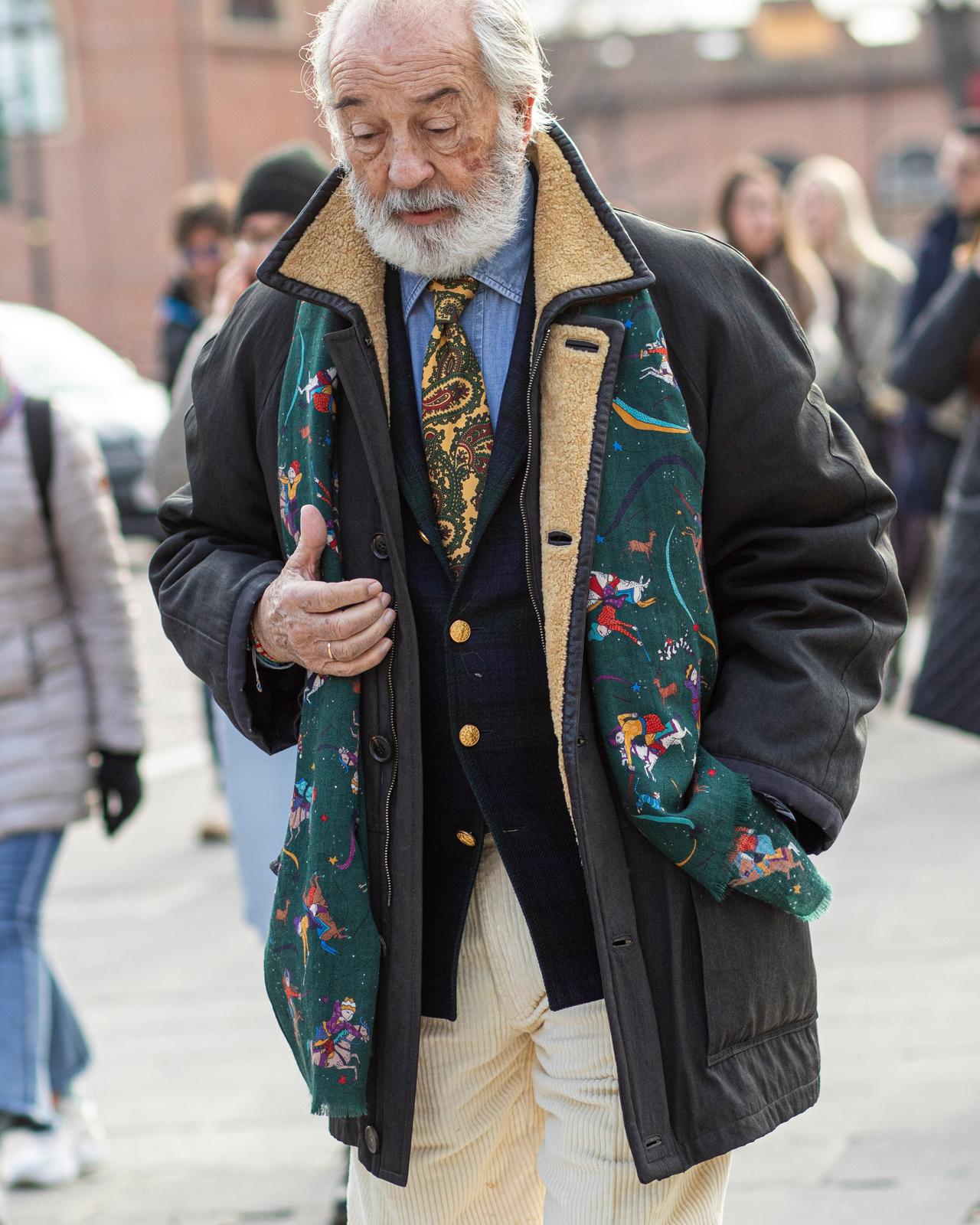 Homme portant une tenue superposée avec une écharpe à motifs