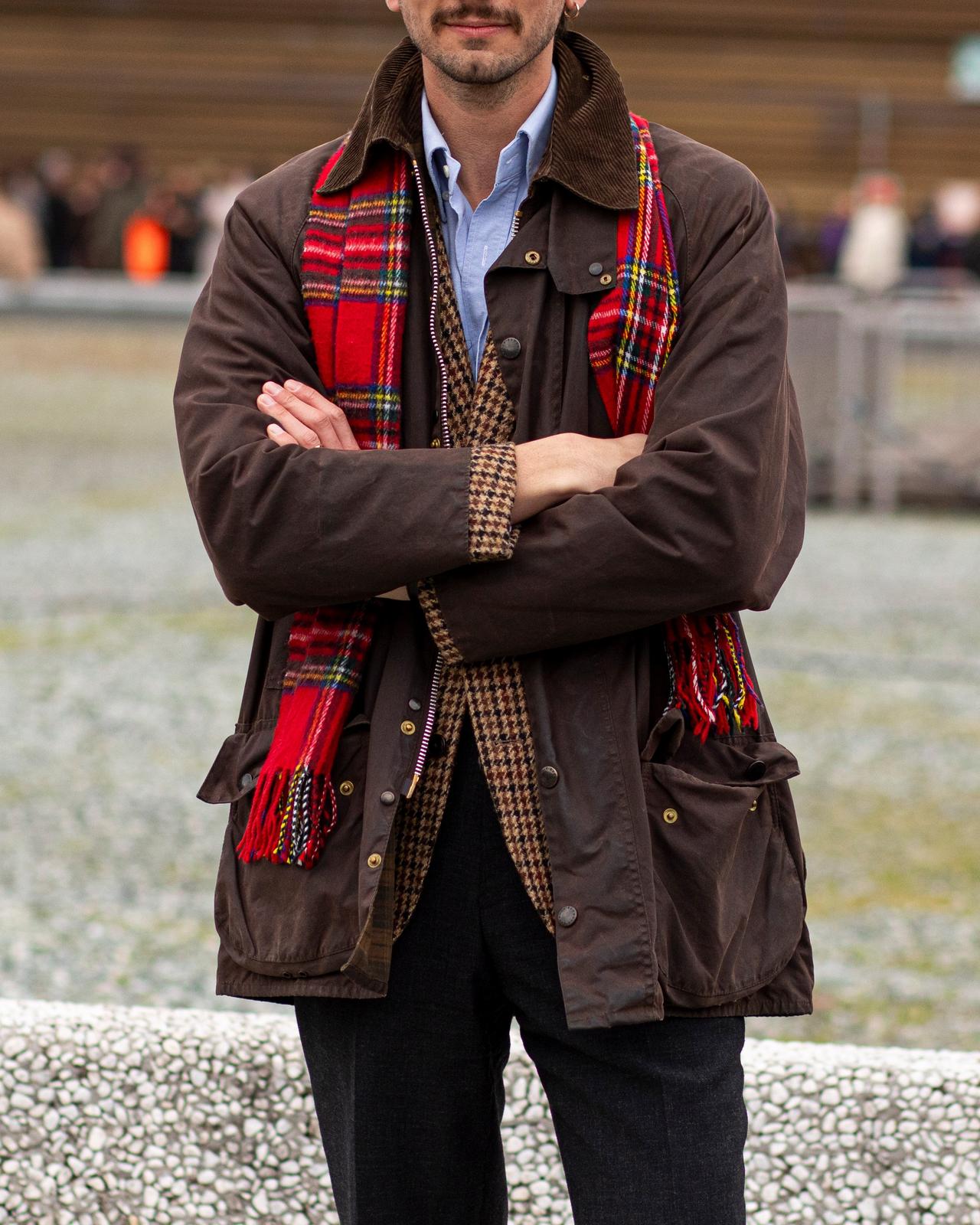 Man wearing layered outfit look with patterned scarf