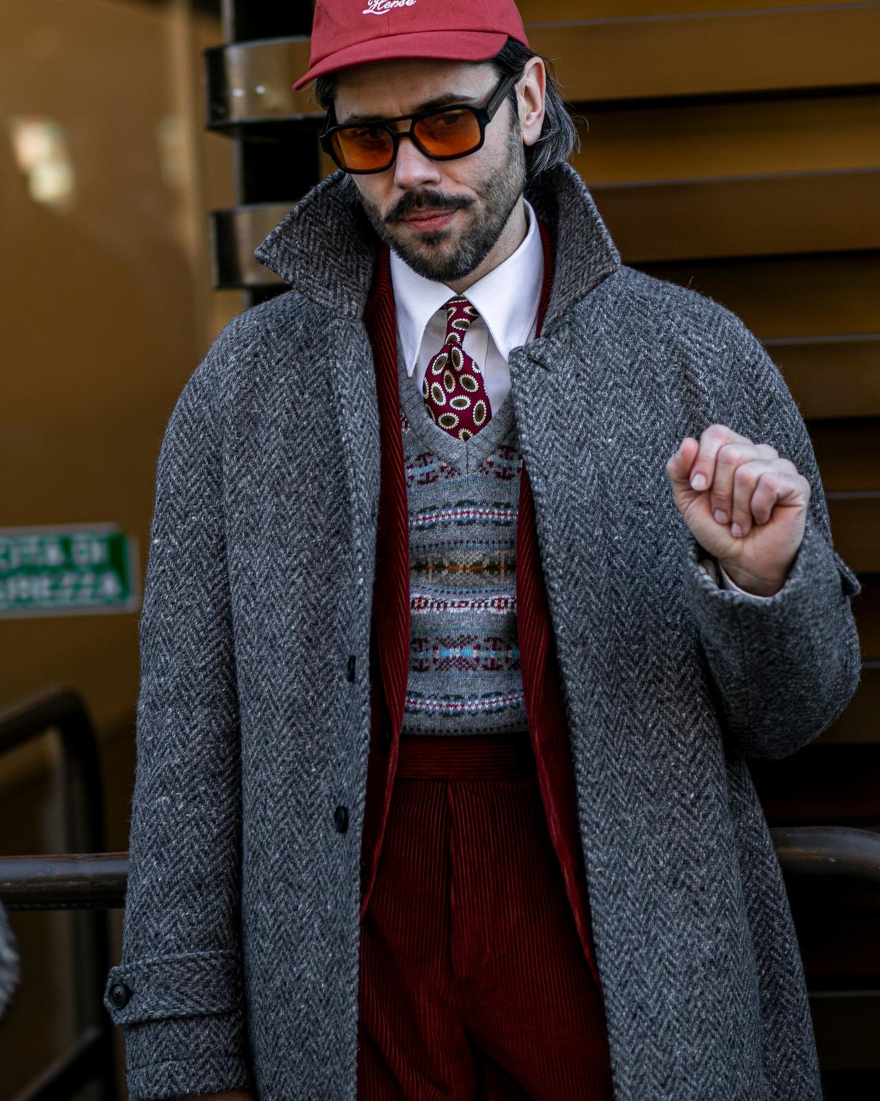 Man wearing layered outfit look with vibrant tie