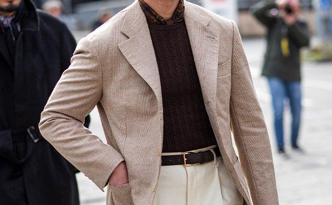 Un mannequin masculin marchant dans la ville, adoptant le style street style de Pitti Uomo