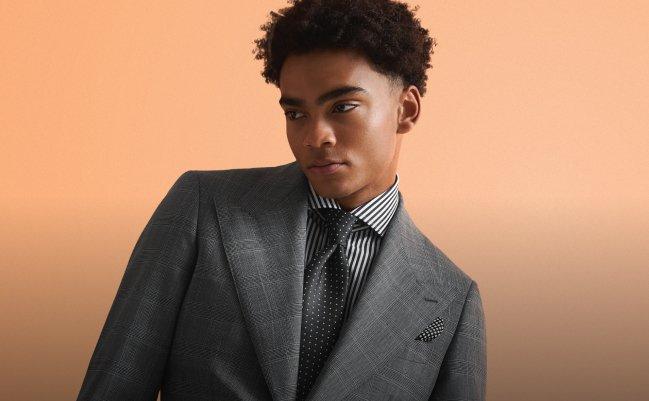 A male model wearing a custom Harold grey tailored suit