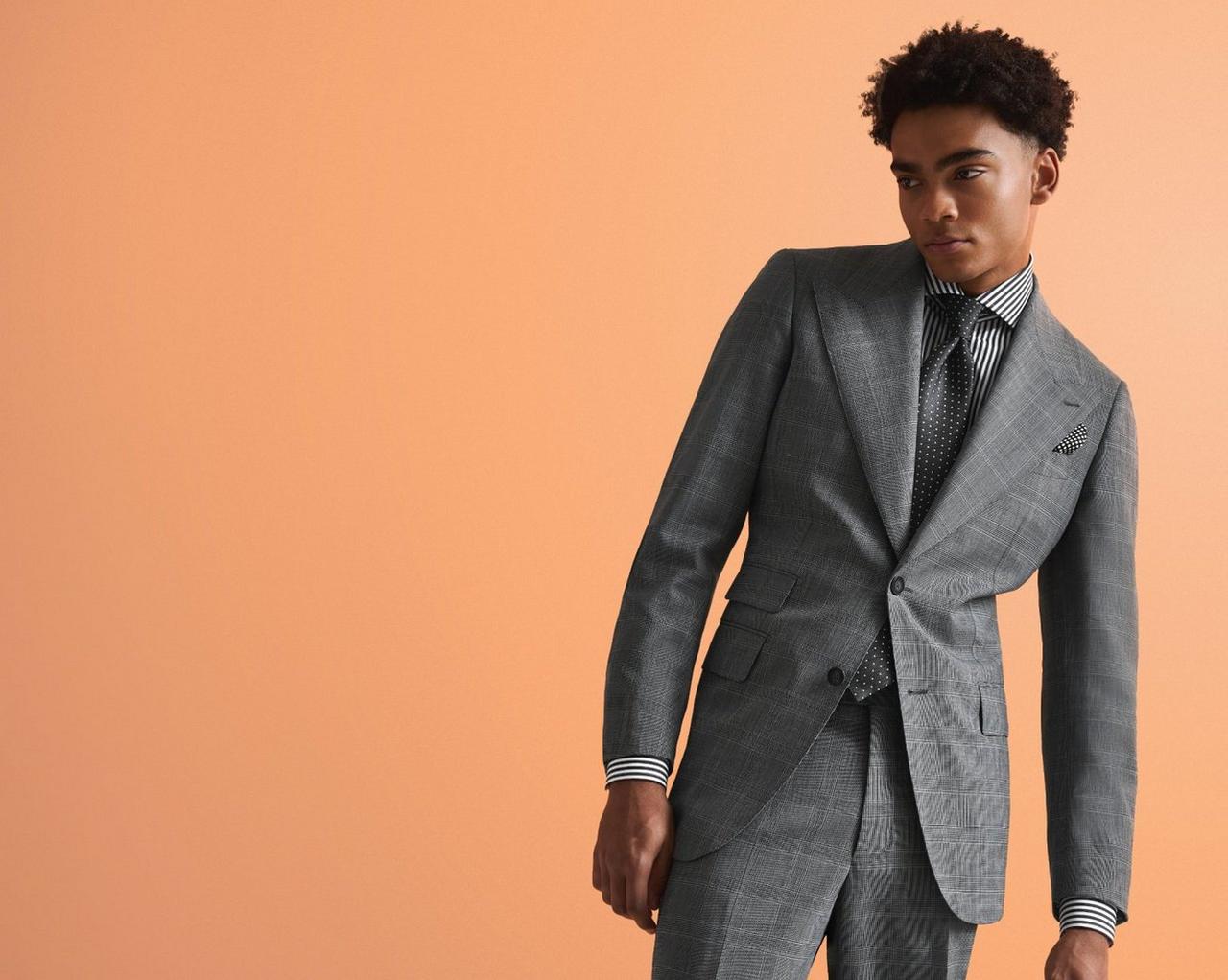 A male model wearing a custom Harold grey tailored suit