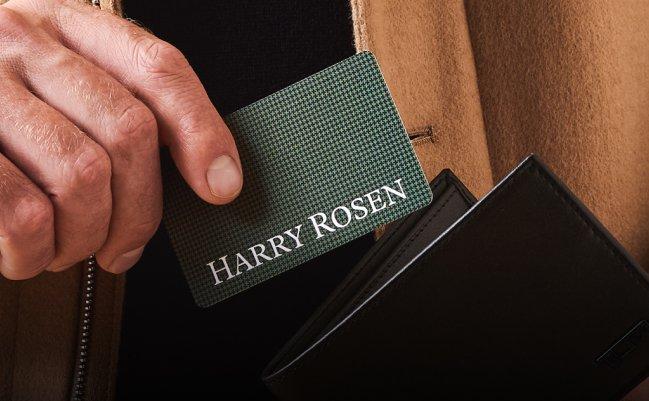 A man's hand holding the Harry Rosen's Gift Card