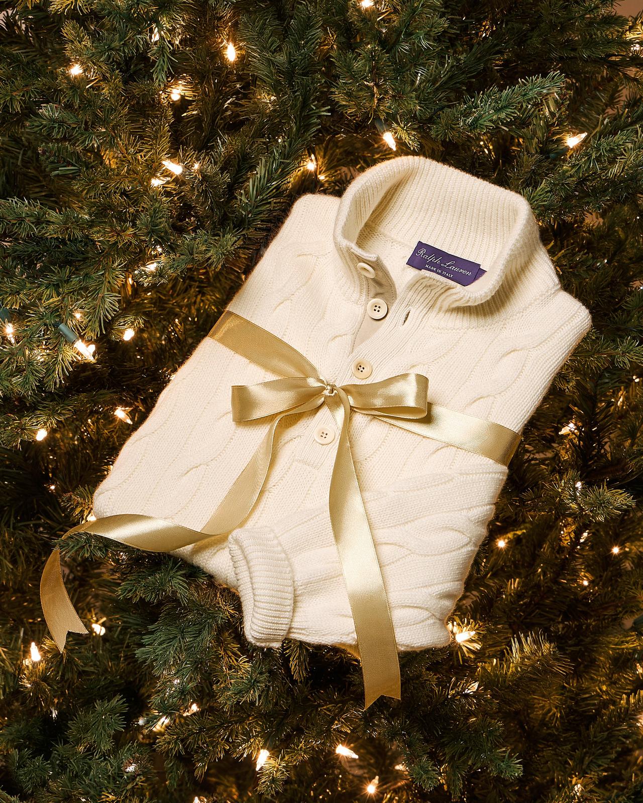 A white cable knit sweater gift wrapped with a ribbon