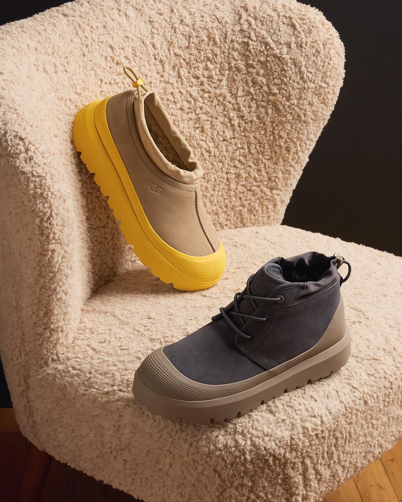 Two styles of UGG Weather Hybrid Shoes, one light brown with yellow outer sole accent, the other black with dark brown outer sole accent