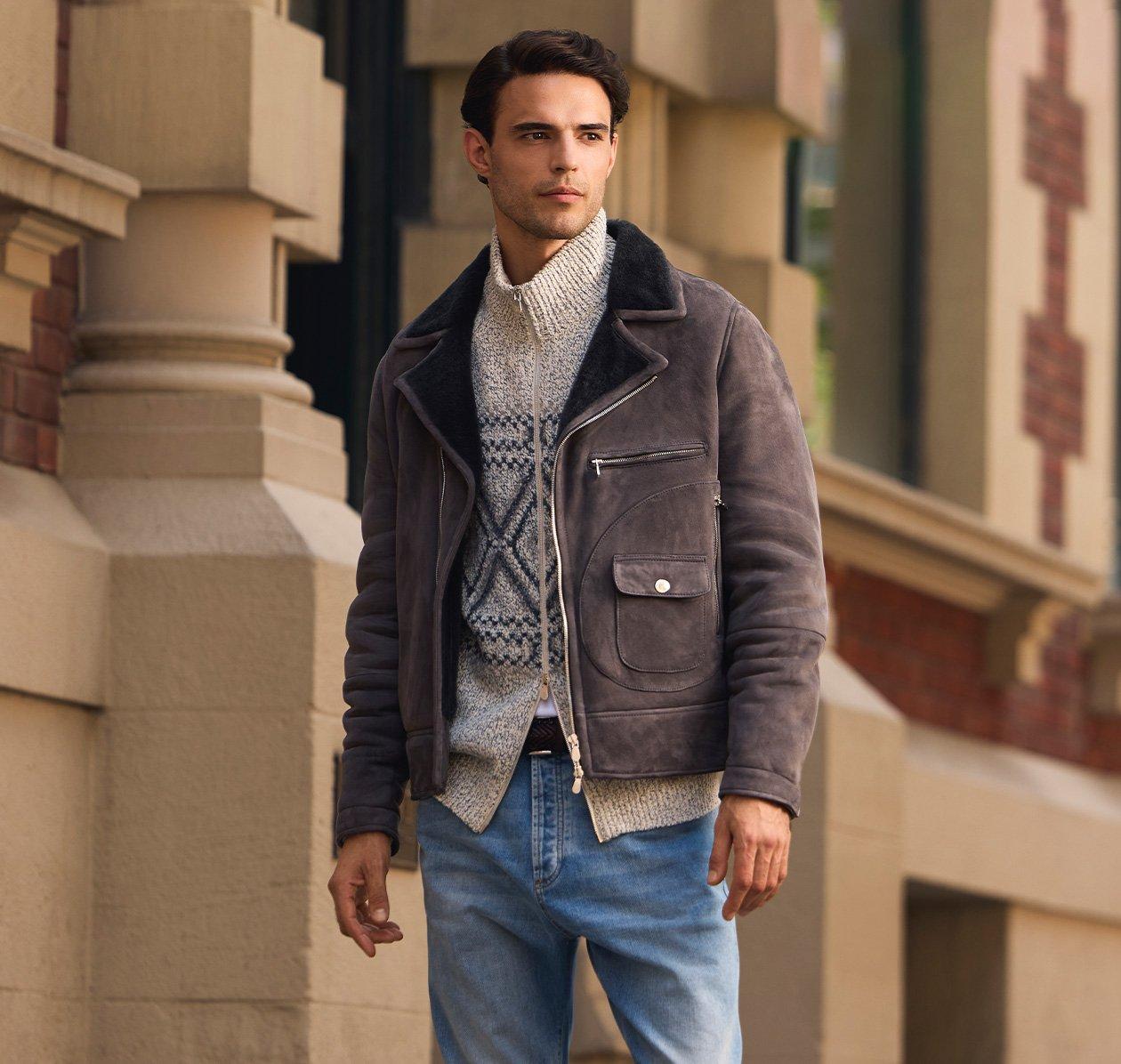 A man wearing purple jacket with cream zip up sweater