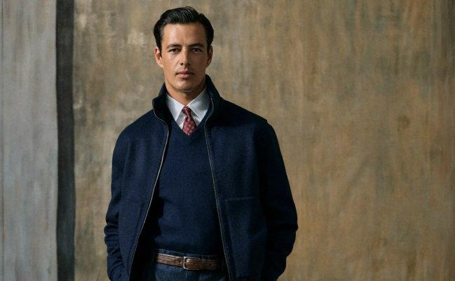 Homme vêtu d’un blazer bleu marine avec un pull assorti, d’une chemise blanche habillée et d’une cravate
