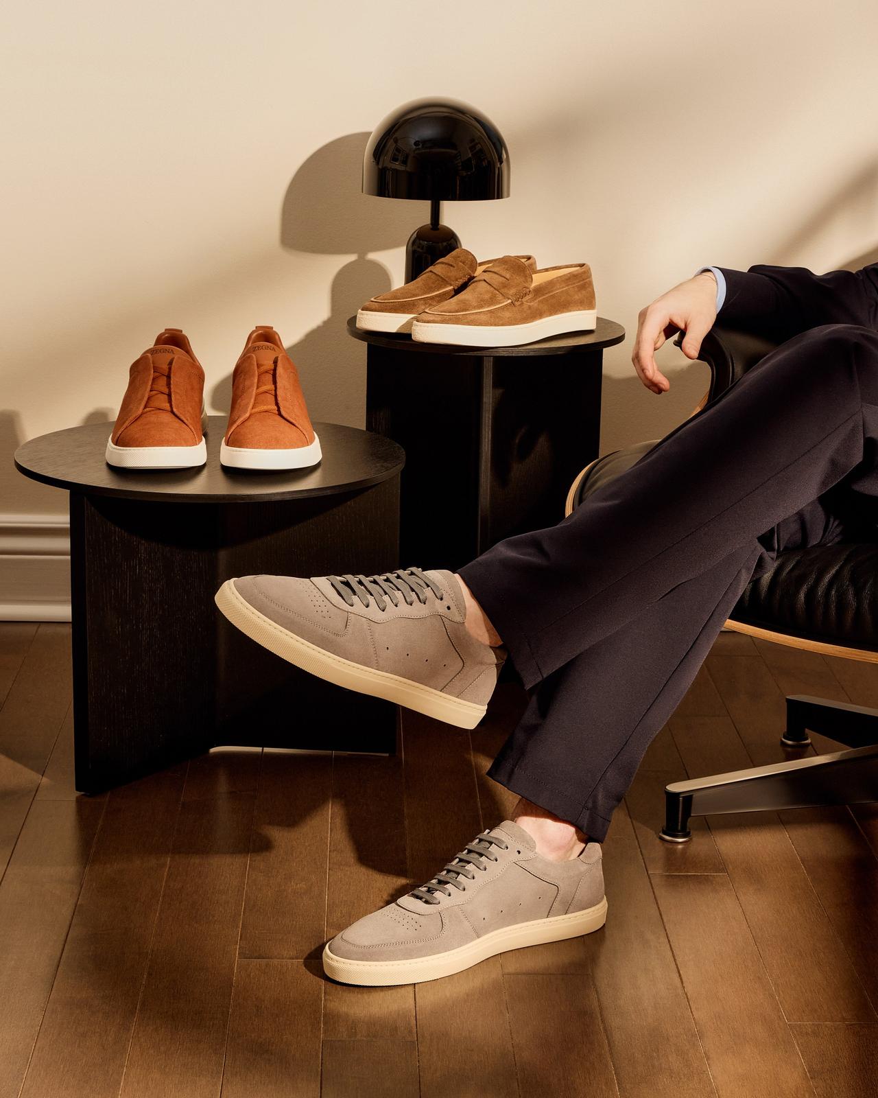 a man sitting in a chair with a pair of shoes on a table