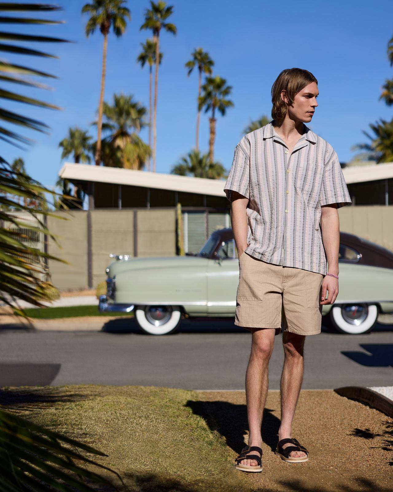 a man in sunglasses and a blue jacket in palm springs