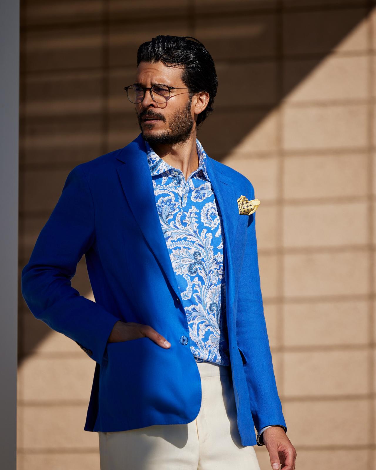 a man in a bright blue sport jacket and patterned sport shirt