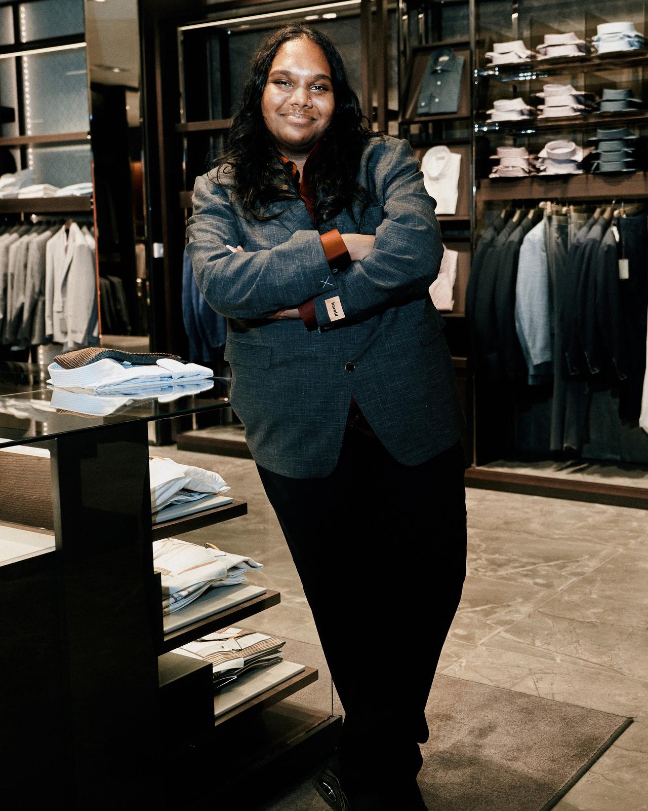 a person standing in a clothing store with his arms crossed